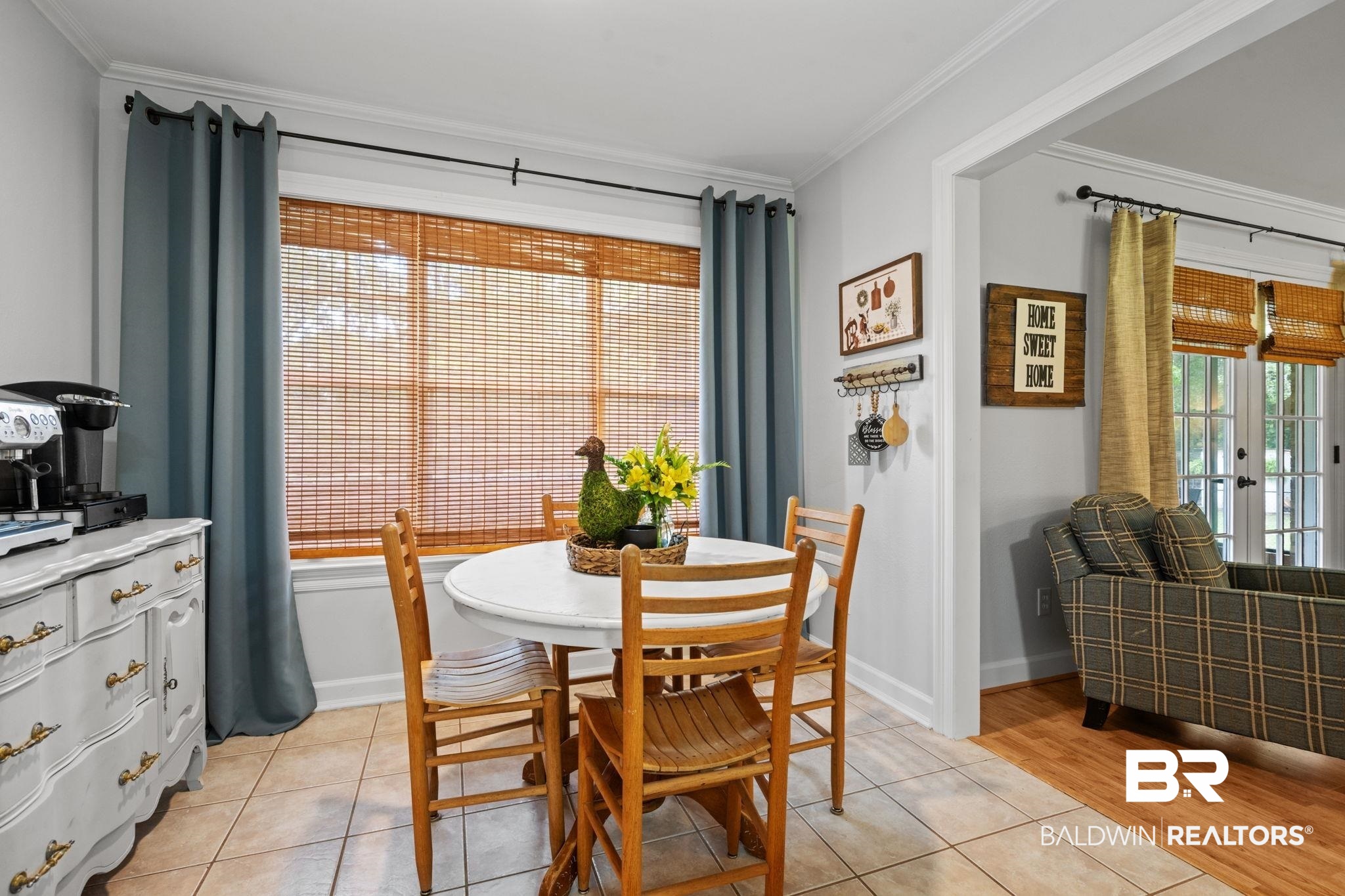 5936 Lundy Road Theodore, AL 36582 - Photo 10 of 32 Spacious dining area featuring neutral tile flooring, a large window with bamboo blinds, and a built-in wall rack for organization