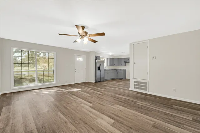 a view of empty room with wooden floor and window