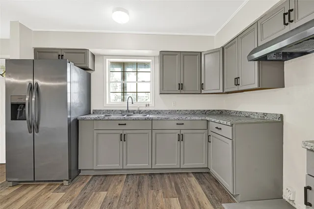 a kitchen with stainless steel appliances granite countertop a refrigerator and a sink