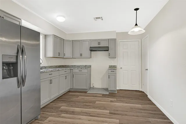 a kitchen with stainless steel appliances a refrigerator and a stove top oven