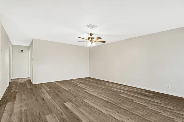a view of a room with wooden floor and a ceiling fan