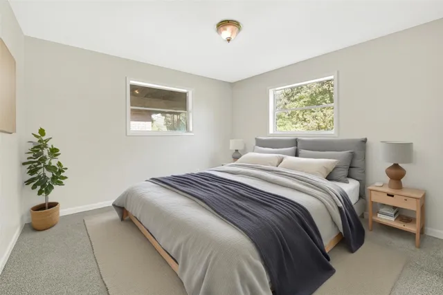 a bedroom with a bed and a potted plant