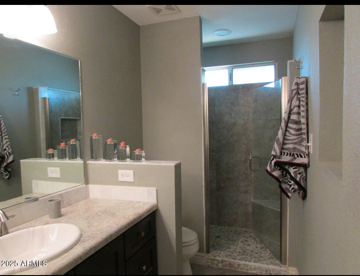 9438 East Michigan Avenue Sun Lakes, AZ 85248 - Photo 16 of 28 a bathroom with a granite countertop sink a mirror and shower