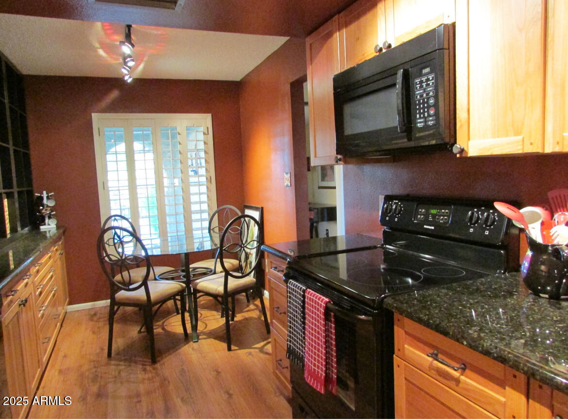 9438 East Michigan Avenue Sun Lakes, AZ 85248 - Photo 6 of 28 a kitchen with granite countertop wooden cabinets dining table and chairs