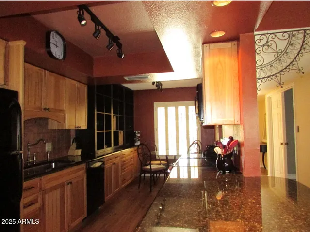 a kitchen with stainless steel appliances granite countertop a stove a sink dishwasher and cabinets with wooden floor