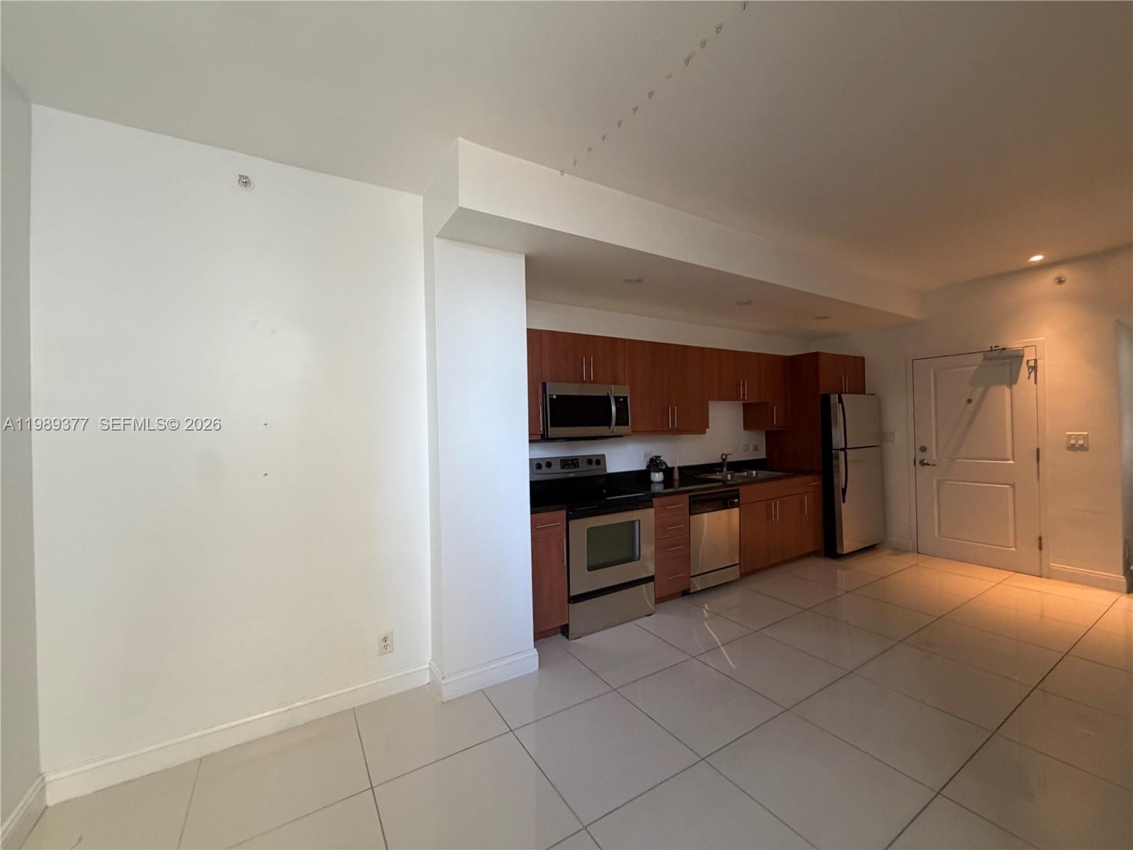 111 East Flagler Street, Unit 606 Miami, FL 33131 - Photo 4 of 10 a large kitchen with cabinets and stainless steel appliances