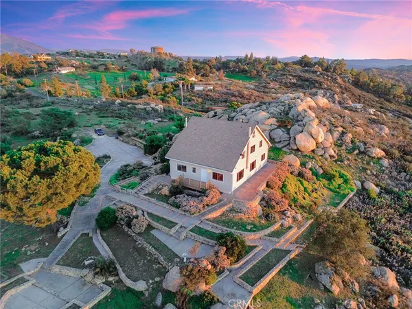 an aerial view of a house with a mountain