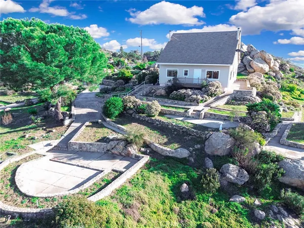 a view of a house with backyard water fountain and sitting area
