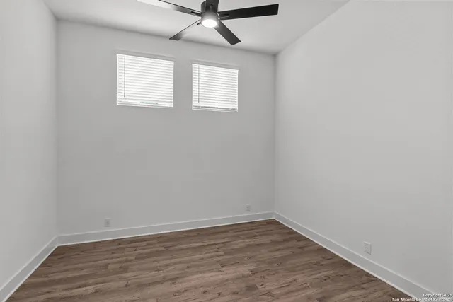 an empty room with wooden floor and window