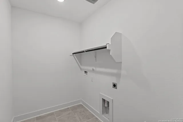 an empty room with wooden floor exposed radiator and windows