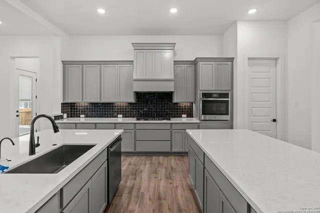 a kitchen with sink stove and refrigerator