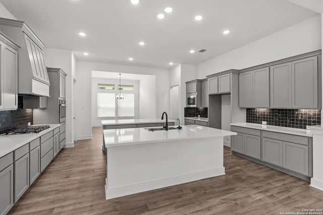 an empty room with wooden floor ceiling fan and windows