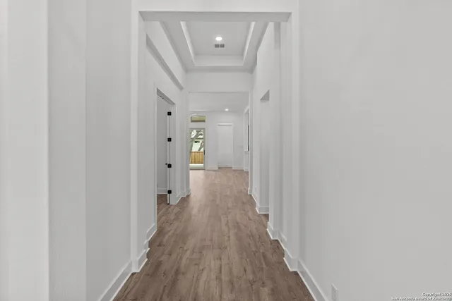 a view of a hallway with wooden floor and staircase