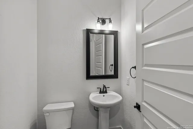 a bathroom with a toilet sink and mirror