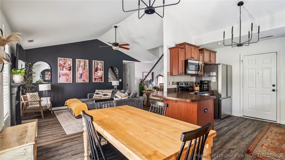 230 Michael Drive Raeford, NC 28376 - Photo 12 of 43 a kitchen with stainless steel appliances kitchen island granite countertop a stove a refrigerator a oven a dining table and chairs with wooden floor