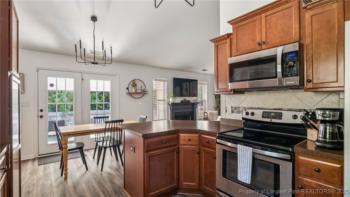 230 Michael Drive Raeford, NC 28376 - Photo 16 of 43 a kitchen with stainless steel appliances granite countertop a stove a microwave cabinets and a dining table