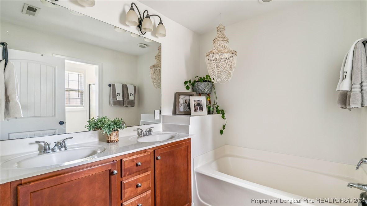 230 Michael Drive Raeford, NC 28376 - Photo 21 of 43 a bathroom with a granite countertop sink a toilet a mirror a bathtub and shower