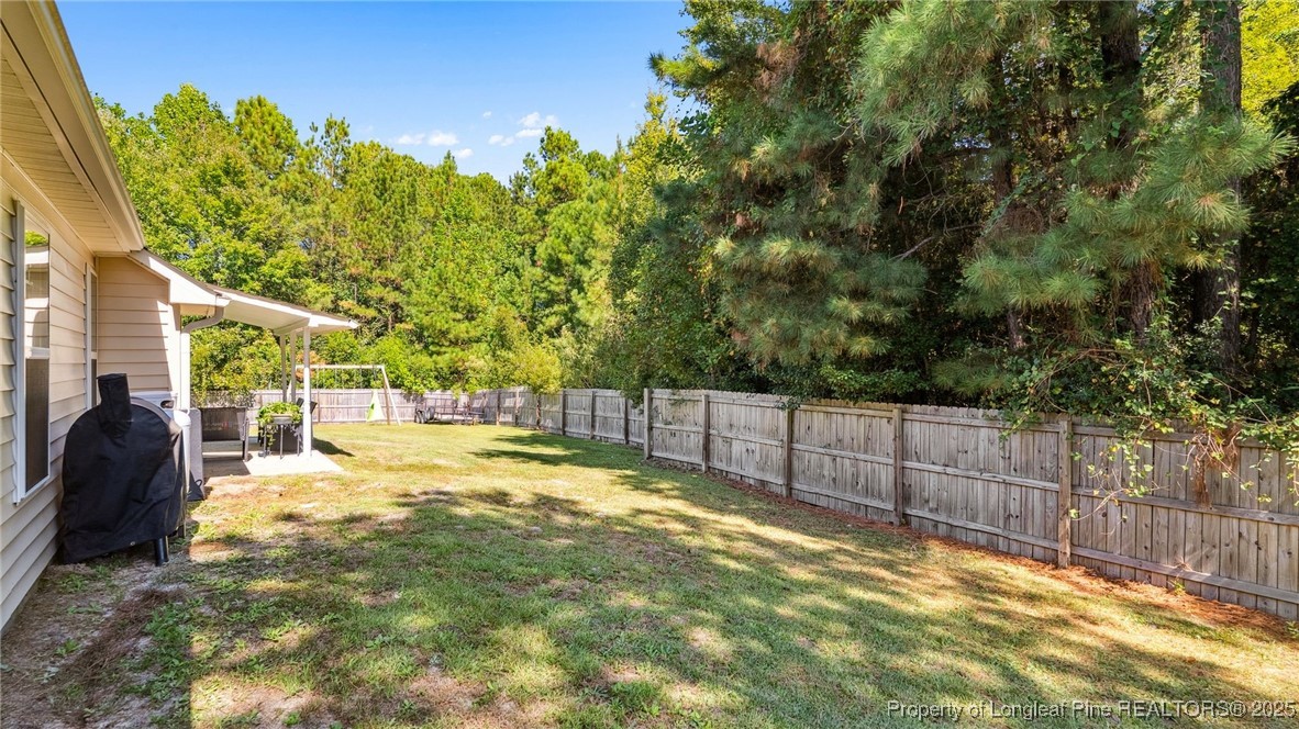 230 Michael Drive Raeford, NC 28376 - Photo 32 of 43 a view of a backyard with large trees and wooden fence