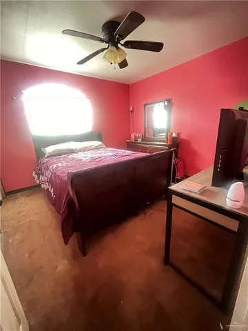 a bedroom with a bed and a ceiling fan
