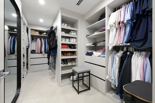 a view of walk in closet with clothes and shoes