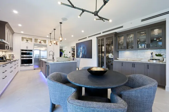 a kitchen with a table chairs and flat screen