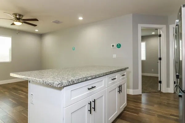 a kitchen with granite countertop a sink and a refrigerator