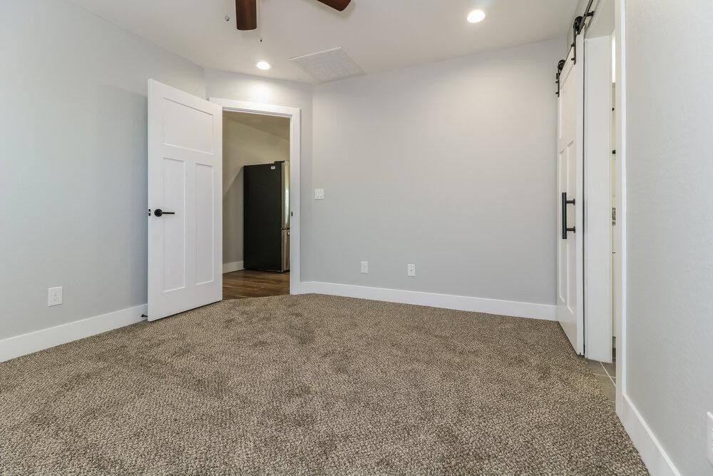 3865 West Gaby Road Phoenix, AZ 85041 - Photo 10 of 16 an empty room with closet and a chandelier fan
