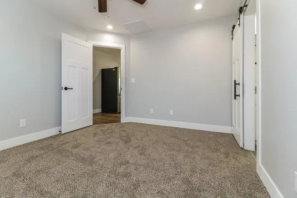 an empty room with closet and a chandelier fan