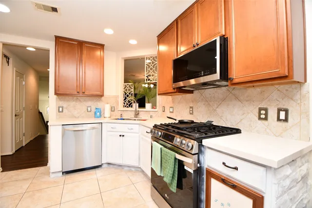 a kitchen with stainless steel appliances a stove a sink and a microwave
