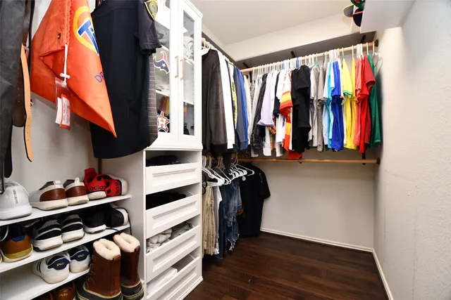 a view of walk in closet with clothes and shoes