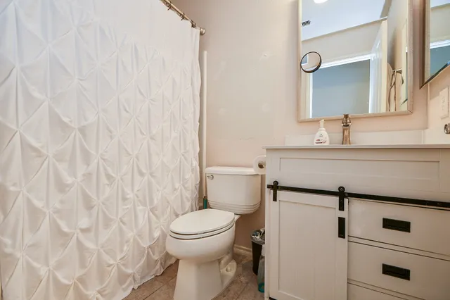 a bathroom with a toilet sink and mirror