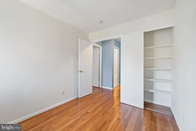 a view of empty room with wooden floor
