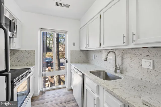 a kitchen with stainless steel appliances granite countertop a sink stove and cabinets
