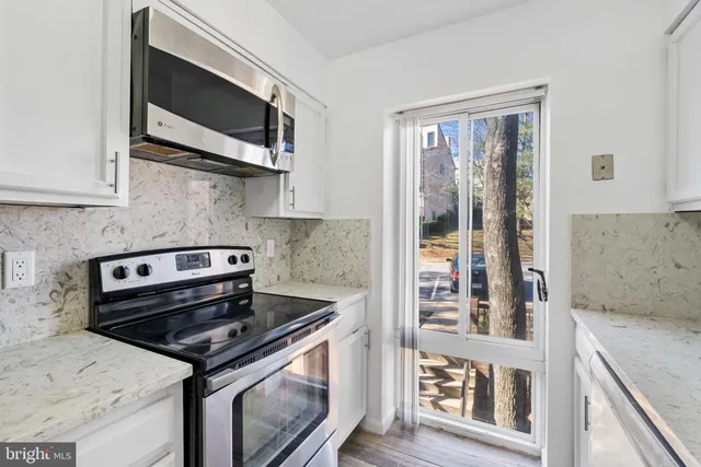 a kitchen with stainless steel appliances granite countertop a stove and a microwave