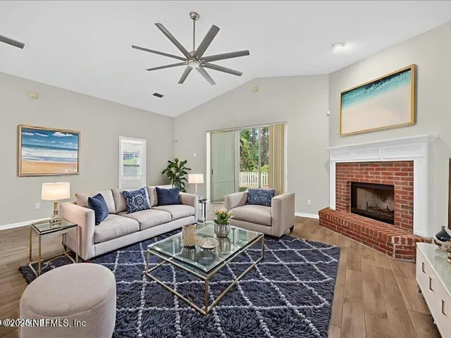 a view of an empty room with a window and fireplace