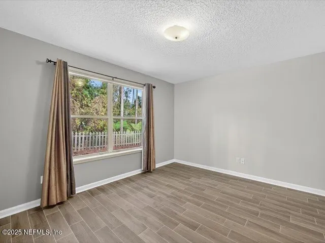a view of a livingroom with wooden floor and window