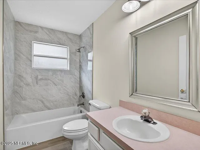 an empty room with wooden floor a fireplace and chandelier fan