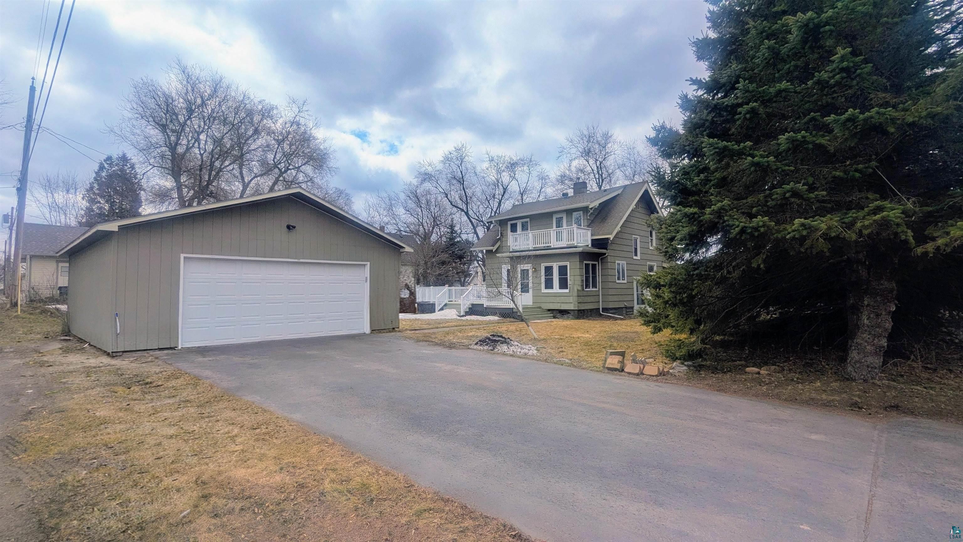 402 3rd Street Cloquet, MN 55720 - Photo 3 of 5 View of front of home with an outdoor structure, a detached garage, a chimney, and a front lawn