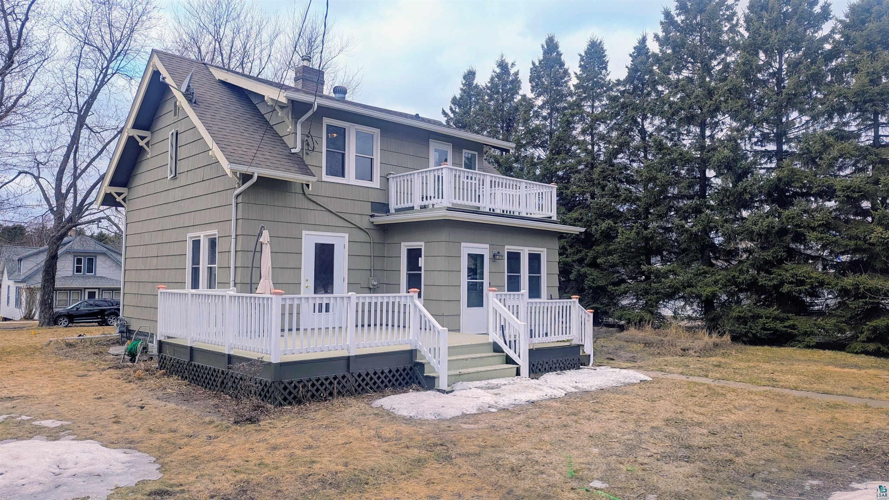 402 3rd Street Cloquet, MN 55720 - Photo 5 of 5 View of front of house featuring a balcony, a chimney, a shingled roof, a deck, and a front yard
