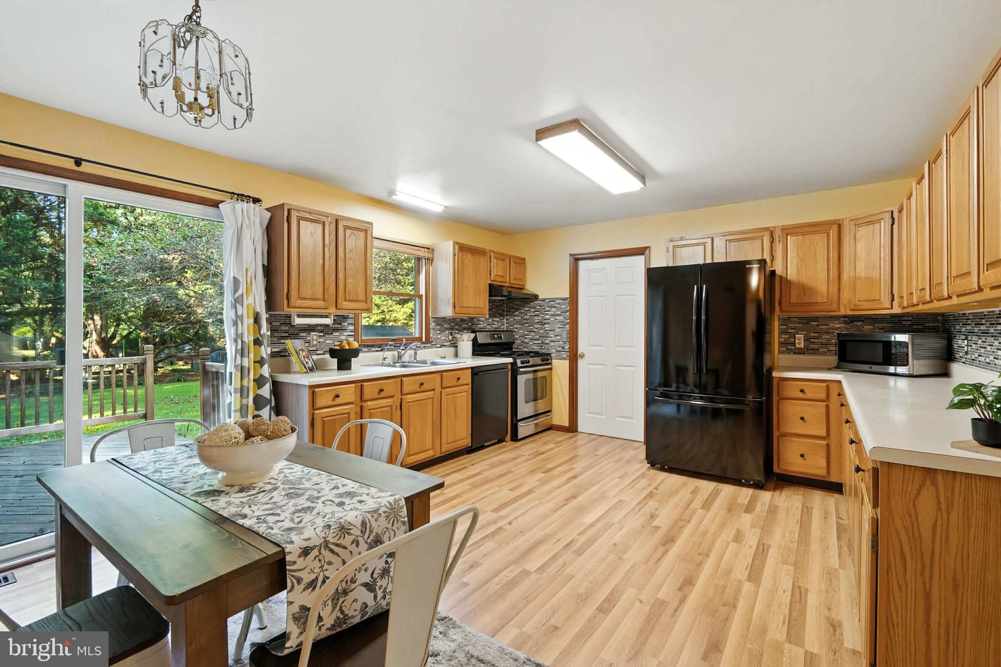105 Parma Road Chestertown, MD 21620 - Photo 5 of 28 a kitchen with stainless steel appliances granite countertop a refrigerator a stove a sink dishwasher a dining table and chairs with the large window