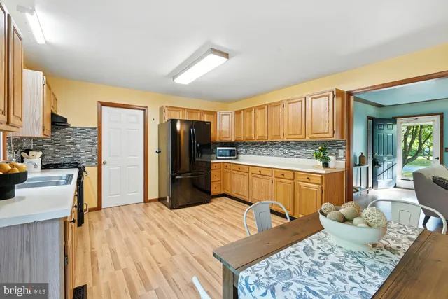 a kitchen with stainless steel appliances granite countertop a refrigerator stove top oven and sink