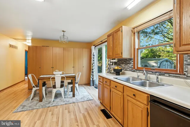 a view of a a dining room with furniture window and wooden floor