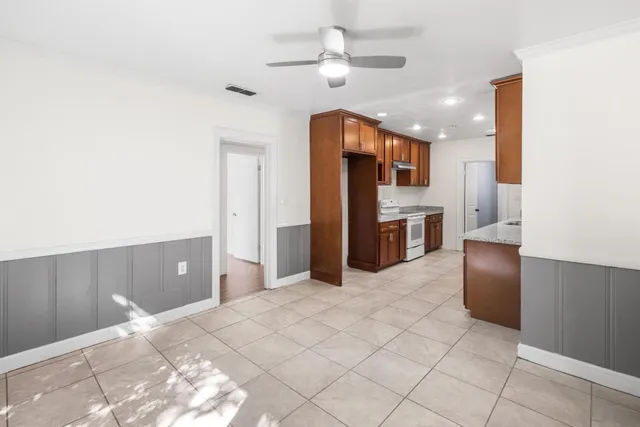 a large kitchen with stainless steel appliances a sink and a refrigerator