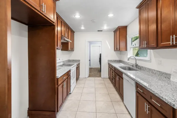 a kitchen with a sink stove top oven and cabinets