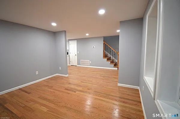 a view of an empty room with wooden floor