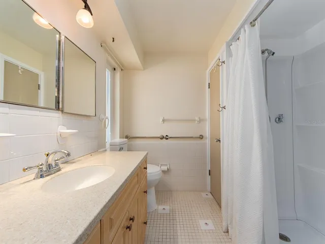 a bathroom with a sink vanity granite and shower