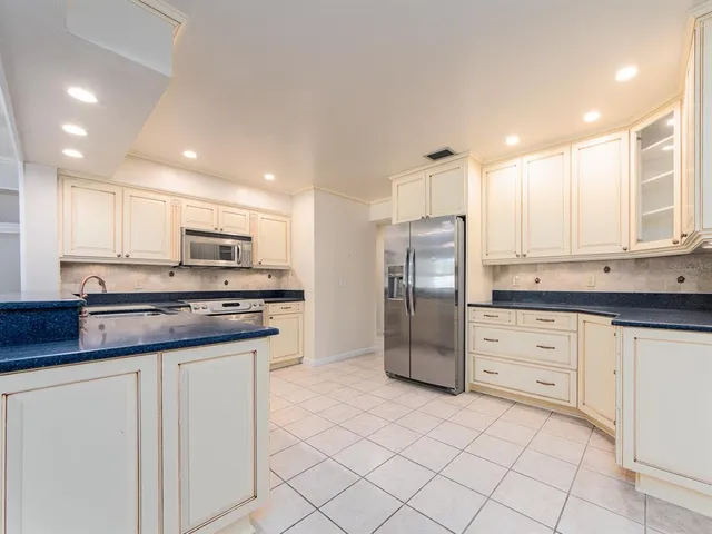 a kitchen with stainless steel appliances granite countertop a refrigerator sink and cabinets