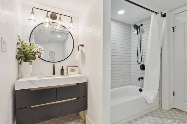 a bathroom with a sink a bathtub and a mirror