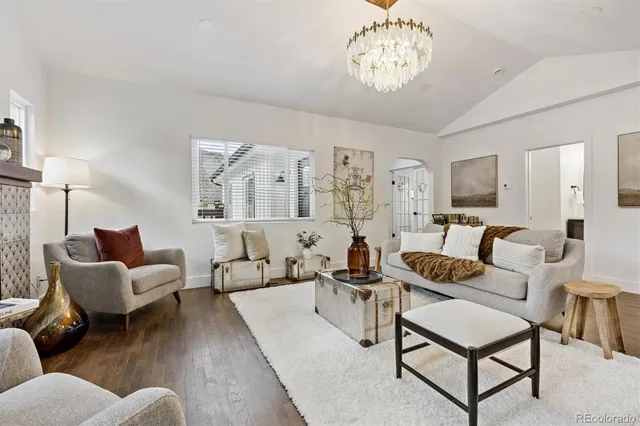 a living room with furniture wooden floor and a chandelier
