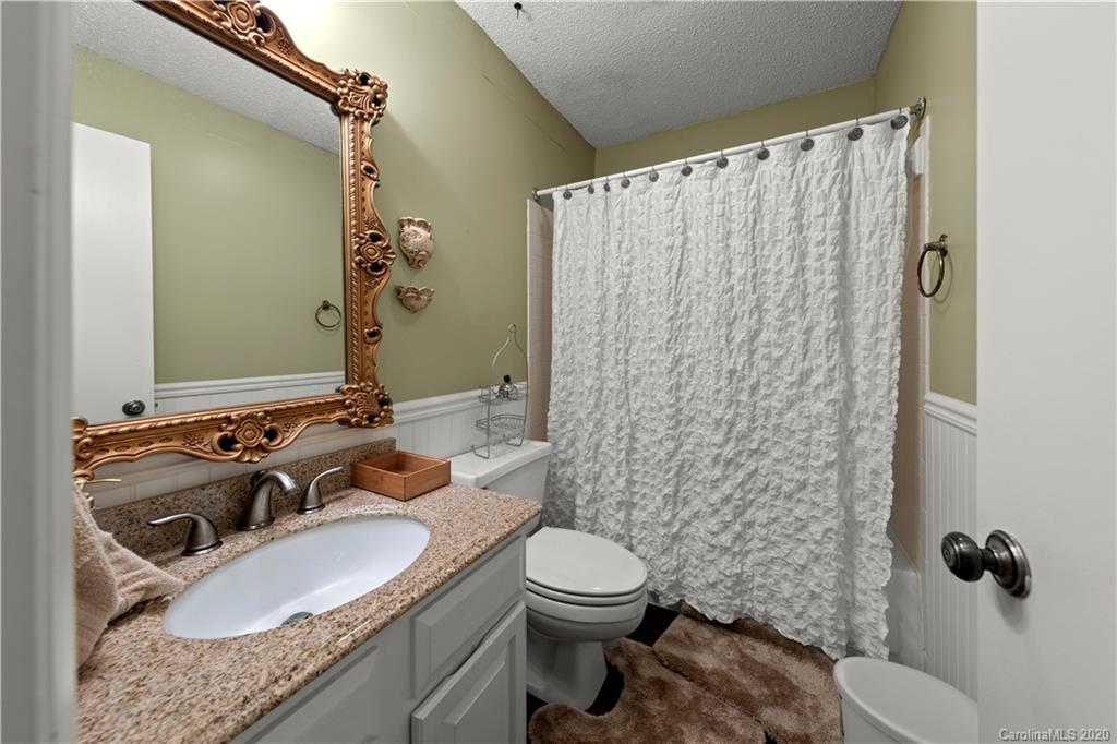 1606 Sharon Road West, Unit 33 Charlotte, NC 28210 - Photo 11 of 19 a bathroom with a granite countertop sink and a mirror